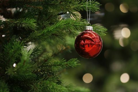 एक क्रिसमस बाउबल एक पेड़ से लटका हुआ है